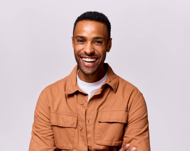 cheerful man in his 30s looking at camera, front view, coloured background